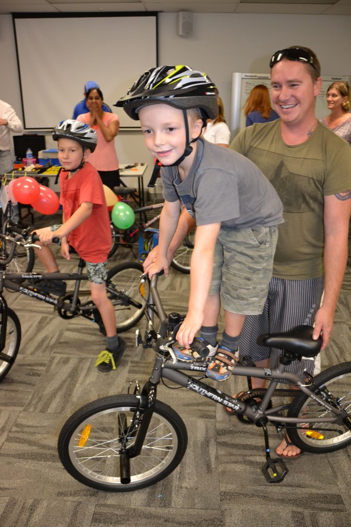 Independent resilient Kids Happy and Standing Tall next to their dad! Thanks to the corporate team building. Build-a Kids-charity bike by Bushsports with Medtronic staff in Sydney.